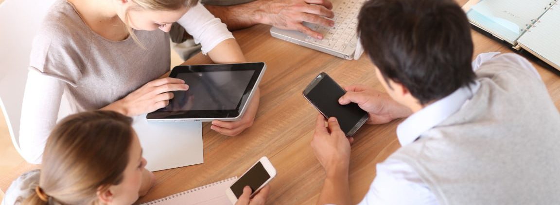 Group of business people using electronic devices at work