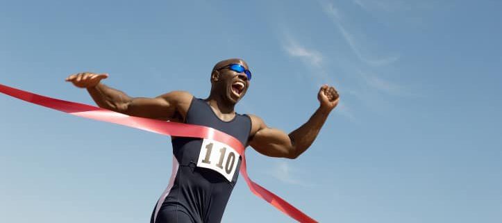Low angle view of an African American male runner winning race a