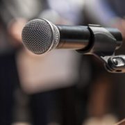 Microphone on the background blurred figures of people during a rally closeup